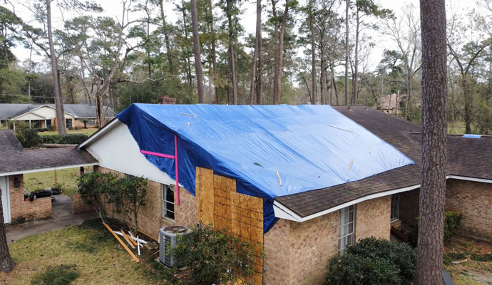 Tarp secured storm damaged house roof